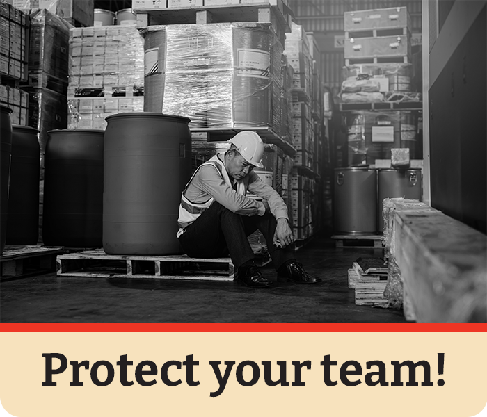 Overheated warehouse worker showing signs of heat exhaustion inside a hot facility, emphasizing the risks of extreme temperatures without proper monitoring and safety solutions.