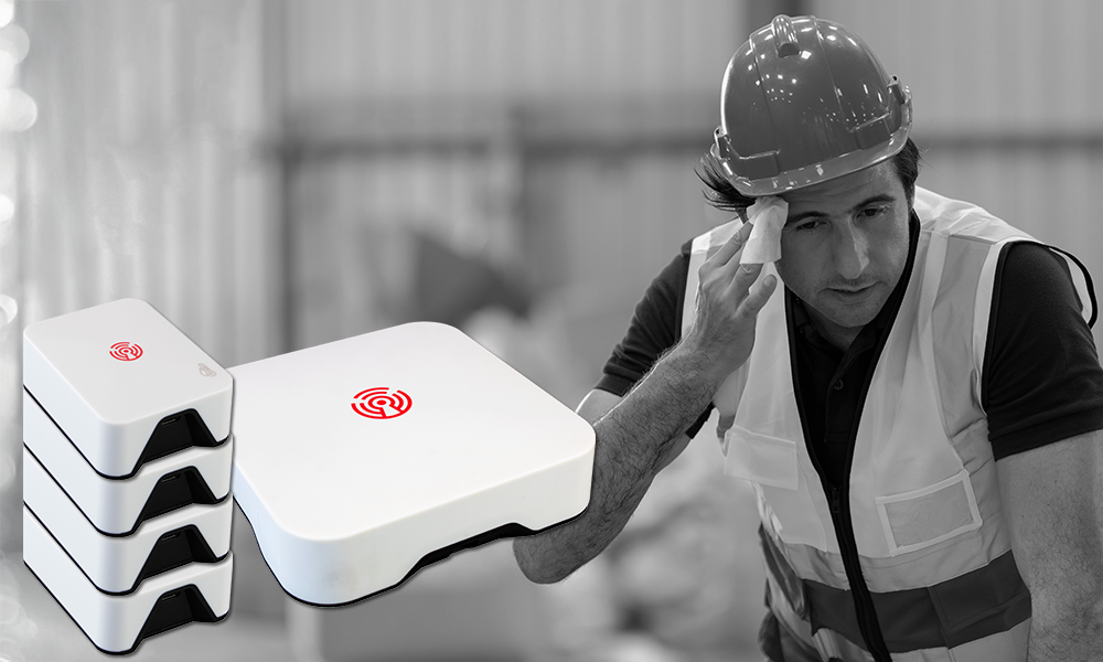 Room Alert MAX Heat Safety Monitor shown in use at an industrial facility where a worker is struggling with heat stress, highlighting the importance of proactive monitoring for employee safety.